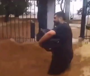 Vídeo mostra morador de Porto Alegre enfrentando ondas do Guaíba para sair de casa